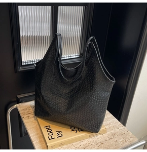 Close-up of black woven leather tote bag with elegant texture for daily commute