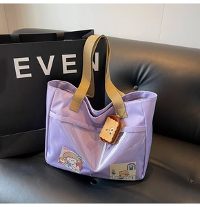 Lavender canvas tote bag detail showing transparent PVC pocket and cute plush charm