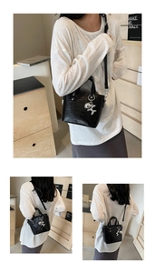 Detail of black glossy patent leather mini bucket bag with silver balloon dog charm