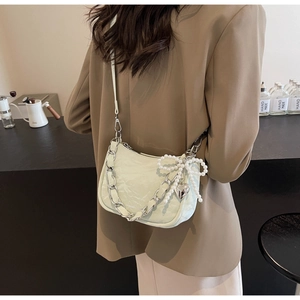 Detail of mint green ruched shoulder bag with pearl bow and silver heart charm