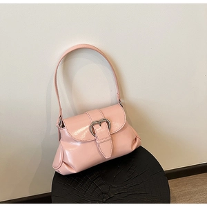 Close-up of pink underarm bag featuring a metallic silver heart buckle and smooth PU leather
