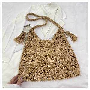 Détail du sac à bandoulière en crochet fait main avec motif en V ajouré et pompon