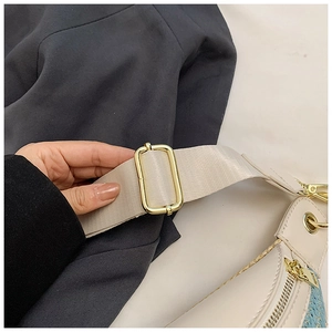 Detailansicht der goldenen Metallschnalle und des Reißverschlusses der Strohtasche