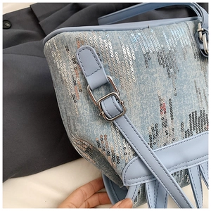 Gros plan sur le denim bleu clair avec paillettes scintillantes et boucle argentée