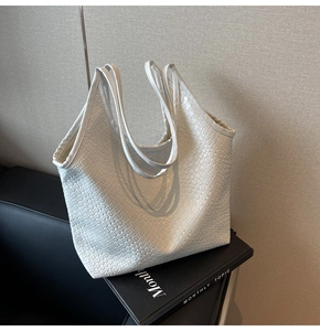 Close-up of white woven tote bag texture with minimalist cross-pattern weave and handles