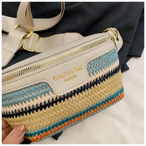 Detail der bunten Strohwebung und des beigen Lederbesatzes mit goldenem Reißverschluss