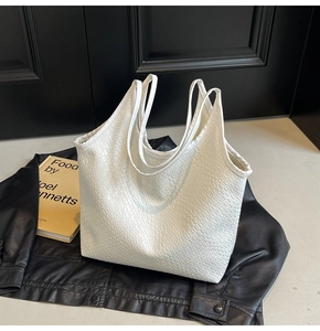 Detail of white woven texture on leather tote bag with sturdy top handles for women