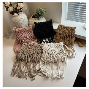 Detailed close-up of handmade woven tassel bags in five colors on a minimalist desk