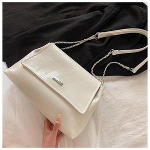 Detailed shot of white textured leather shoulder bag with chain strap on a blazer