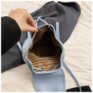 Vue détaillée du sac à dos en jean montrant la doublure rayée et la poche zippée