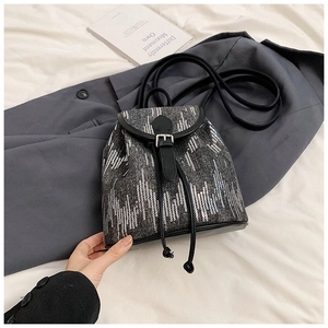 Détail d'un mini sac à dos en jean avec paillettes argentées et finitions en cuir noir