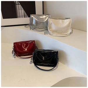 Detail of glossy handbags in four colors featuring metal chains and balloon dog charms