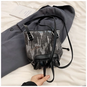 Détails du sac à dos en denim gris avec paillettes argentées et finitions en cuir noir