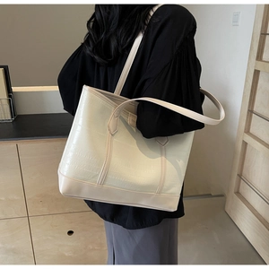 Detail view of large cream tote bag with crocodile pattern texture on leather