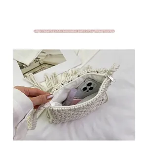 Detail view of the hand-woven cream bag showing spacious interior and fringe