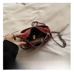 Detailed interior view of red patent leather mini crossbody bag with woven chain strap