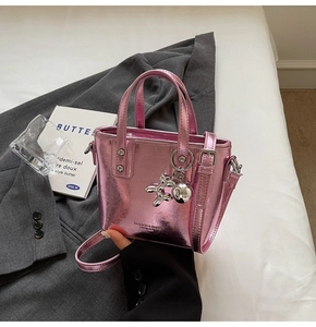 Detail of pink metallic mini bucket bag with silver balloon dog charm and logo