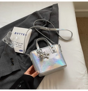 Close-up of holographic silver leather handbag with metallic balloon dog charm