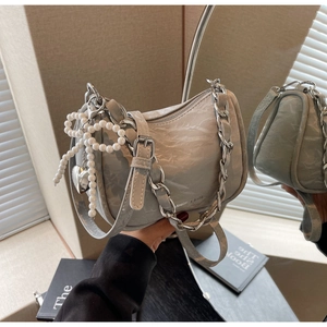 Detail of grey crescent bag with ruched leather and pearl bow heart charm