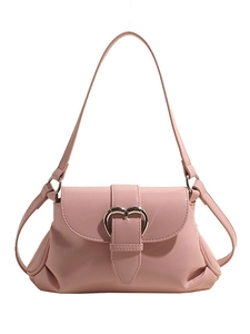 Pink glossy leather shoulder bag for women with golden heart buckle on white background