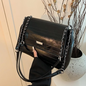 Quilted black leather shoulder bag with silver chain strap and metal clasp detail