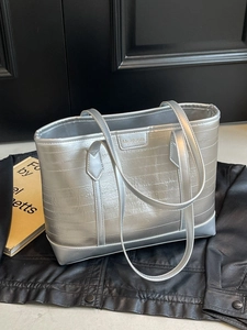 Metallic silver tote bag with horizontal embossed stripes and dual shoulder straps