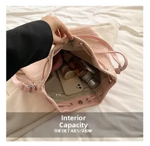 Internal capacity of pink woven drawstring backpack showing phone, wallet and umbrella