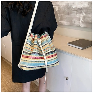Detail of colorful striped woven backpack with drawstring closure worn by a model