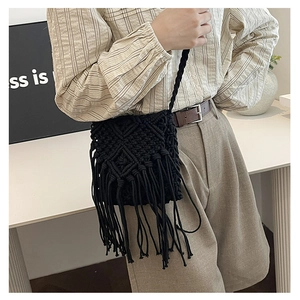 Detail of black macrame crossbody bag with geometric weave and long fringe tassels