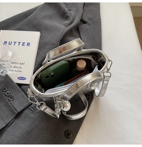 Macro view of silver bucket bag interior showing spacious storage for smartphone and wallet