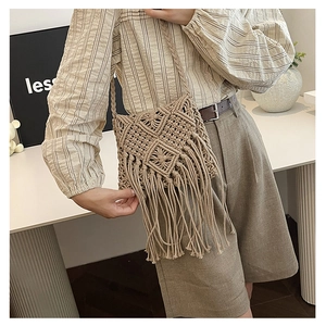 Detailed close-up of a handmade woven saddle bag with long tassels and woven strap