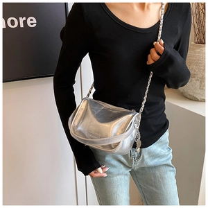 Detail of silver metallic crossbody bag with textured wrinkles and chain strap