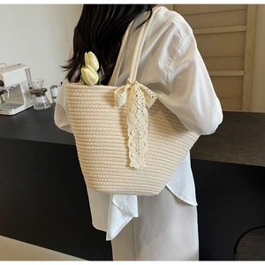Λεπτομέρεια πλεχτής τσάντας με δαντελένιο φιόγκο και τουλίπες σε ζεστό καφέ