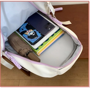Top view showing spacious main compartment with tablet and books inside the beige backpack