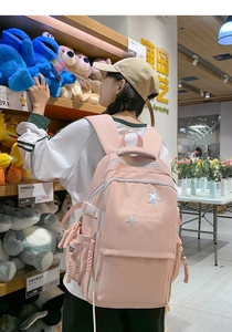 Pink student backpack with star embroidery shown in a lifestyle shopping scene