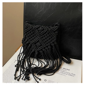 Detailed view of hand-woven black cotton tassel bag with geometric diamond patterns
