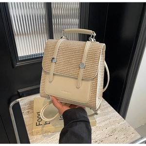 Detail of beige straw texture and white leather trim on a stylish mini backpack