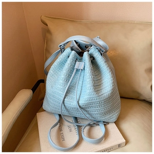 Detail of light blue tweed woven bucket bag with matching leather drawstring and silver hardware