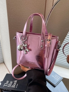 Pink metallic crossbody bucket bag with balloon dog charm and stylish top handle