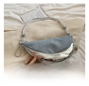 Detail of grey denim and silver leather patchwork on a crescent dumpling shoulder bag