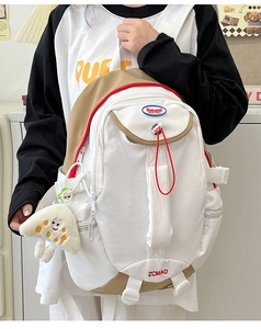 Detail of nylon backpack featuring beige contrast panels and red drawstring pulls
