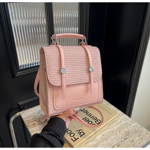 Detailed shot of pink backpack with woven texture flap and silver metal buckles