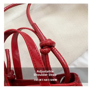 Détail du sac seau rouge à nœud montrant les nœuds de bandoulière réglables et coutures