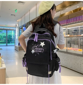Close-up of black ergonomic backpack with star embroidery and purple accents