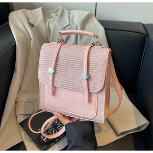 Detail showing pink faux leather and woven texture mix on a stylish backpack