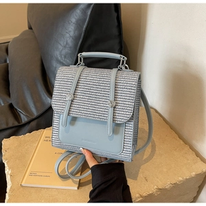 Detailed view of light blue woven texture and leather paneling on a modern backpack