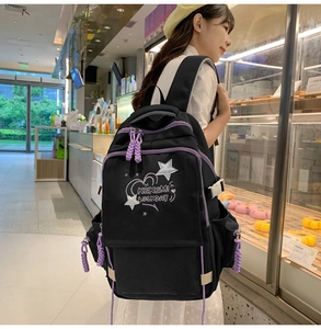 Detail of black canvas backpack with purple zippers and KEKEMI LUCKY DAY embroidery