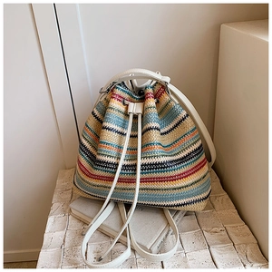 Detail of colorful striped straw backpack with drawstring closure and cream straps