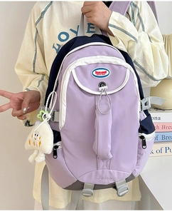 Detail of lavender nylon backpack with navy stitching and plush cloud pendant charm