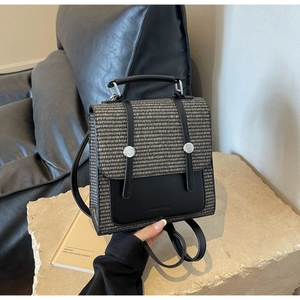 Close-up of bicolor mini backpack featuring contrast weave pattern and silver buckles
